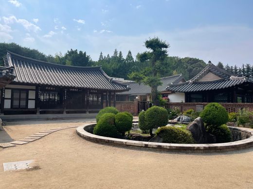 A circular central garden is surrounded by Korean-style buildings