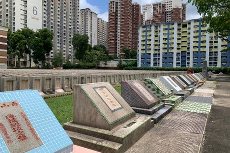 Cemetery with mass graves in the foreground.