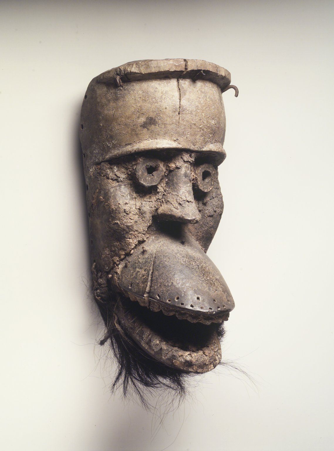 This 19th-century mask, with a hinged jaw, is thought to be a peacemaking one, with its nearly closed eyes and small mouth.