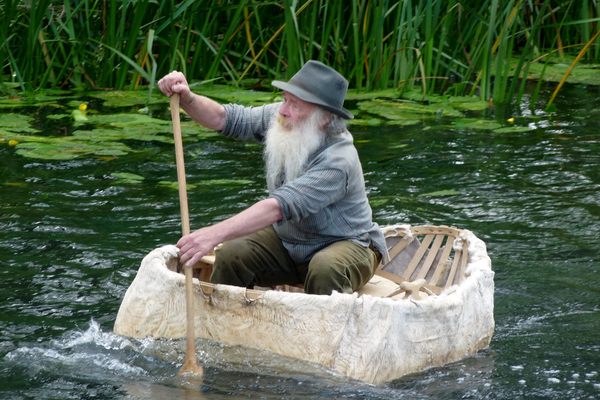 A man rowing a cowskin coracle in Bures, England