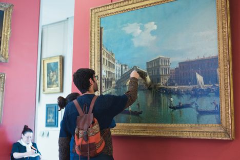 A visitor to the Louvre is tempted by Canaletto's 18th-century painting "The Rialto Bridge in Venice."