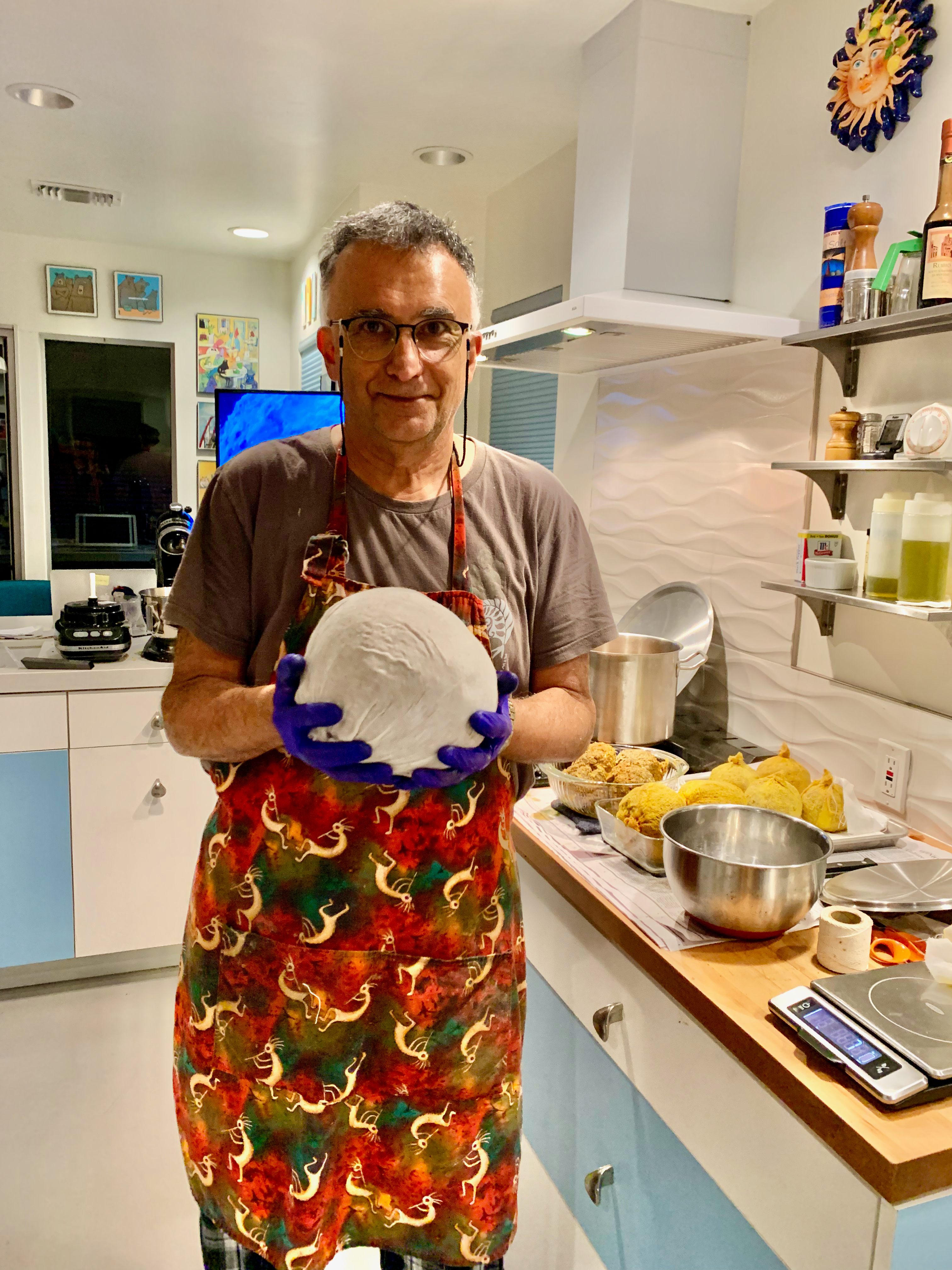 Nader Mehravari in his home kitchen preparing a giant Persian meat dumpling.