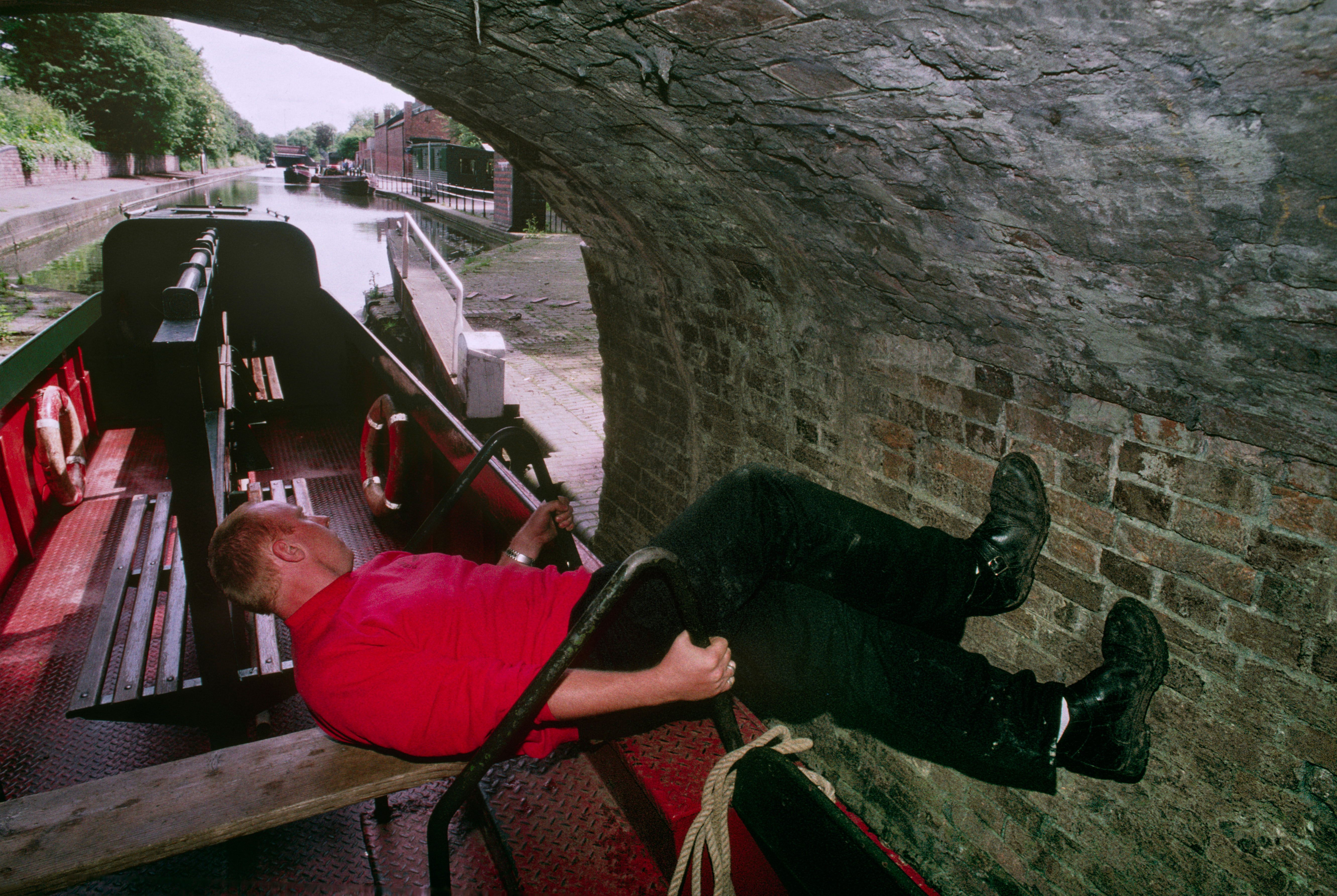 A boatman legging through Dudley tunnel in the West Midlands.