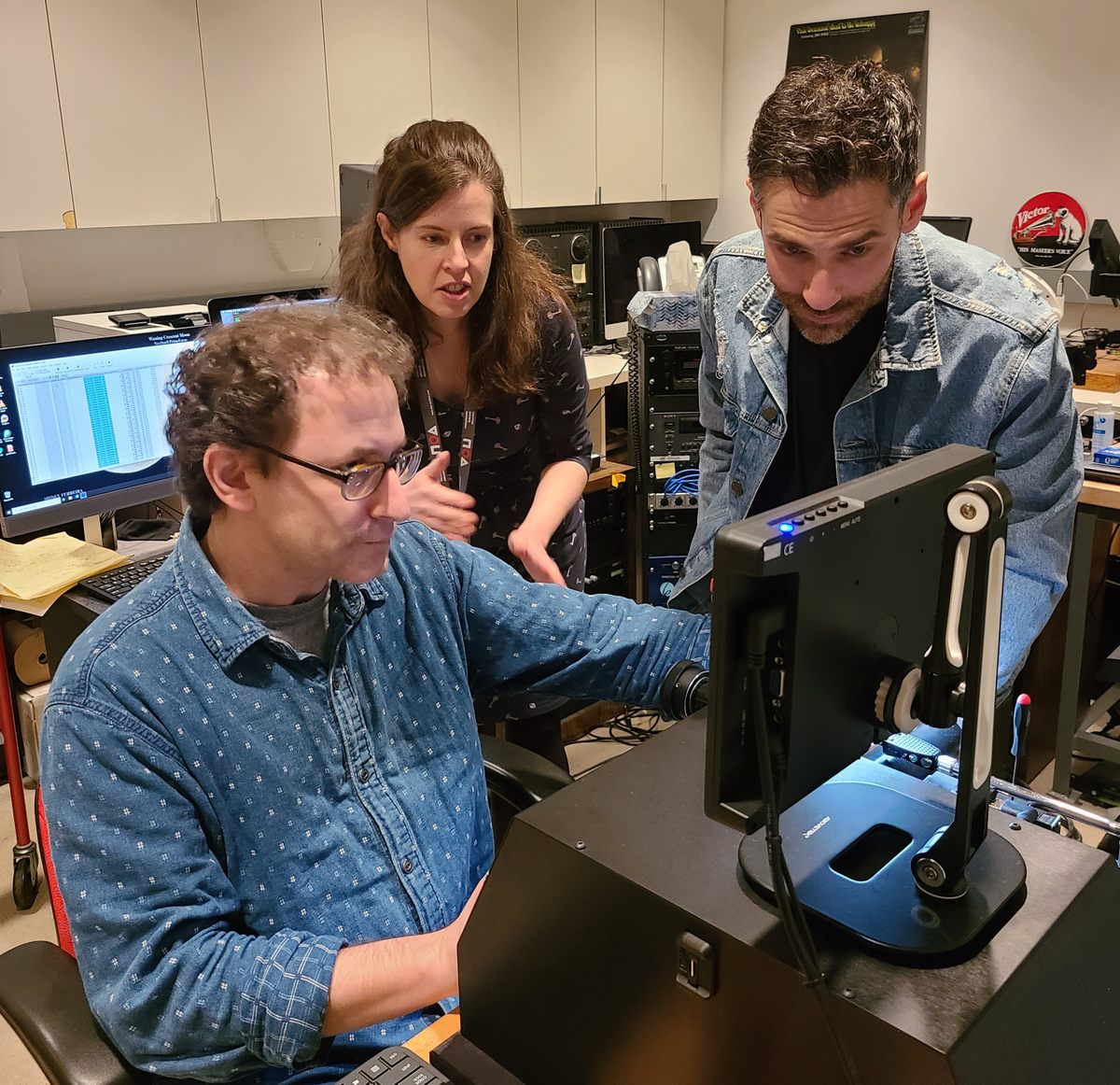 Jeff Willens (left), media preservation engineer, digitizes one of the library's wax cylinders with the Endpoint machine for the first time.  Jessica Wood, assistant curator of music and recorded sound, and Ben Turkus (right), media preservation labs manager, look on.