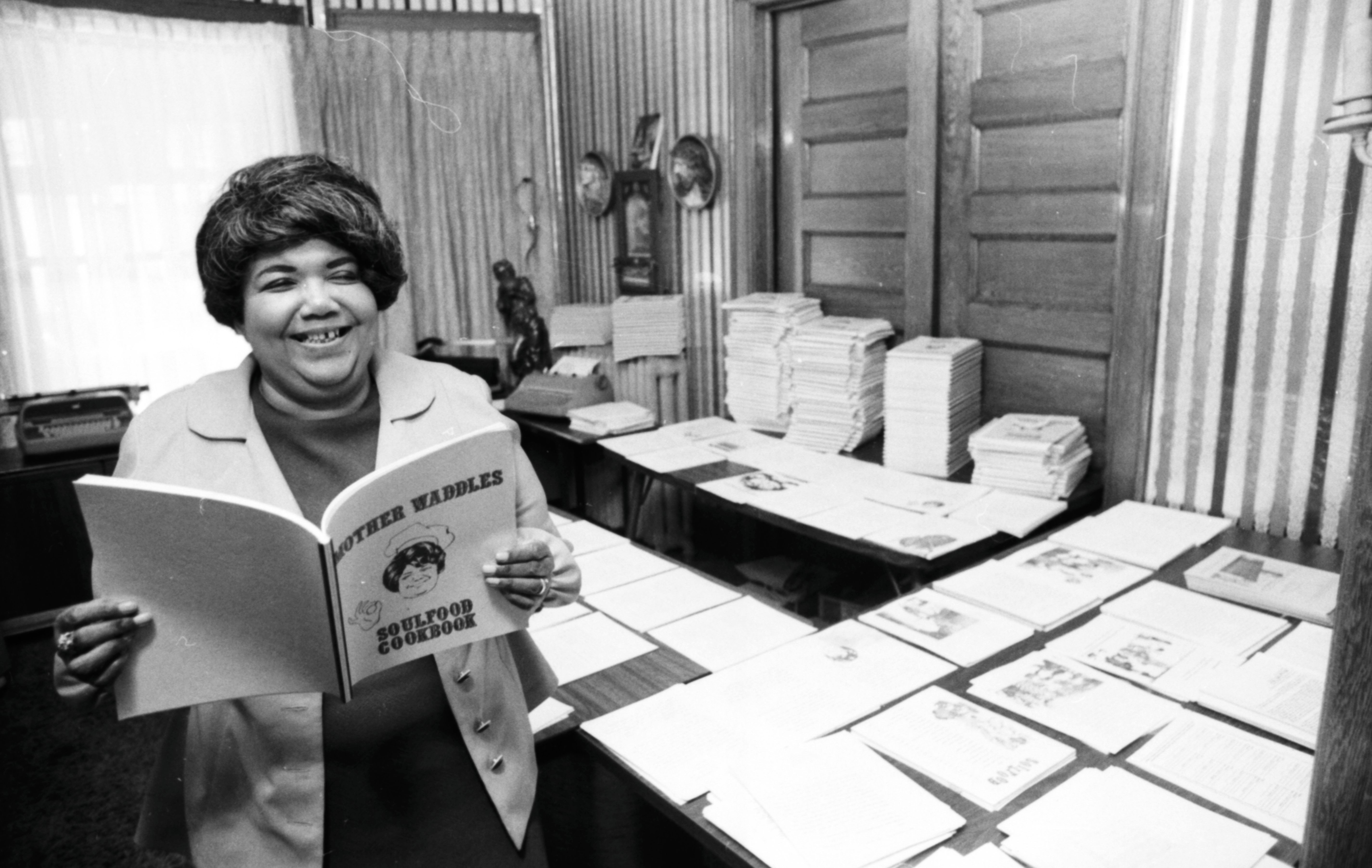 Charleszetta "Mother" Waddles, with a cookbook she self-published to raise money for community programs.