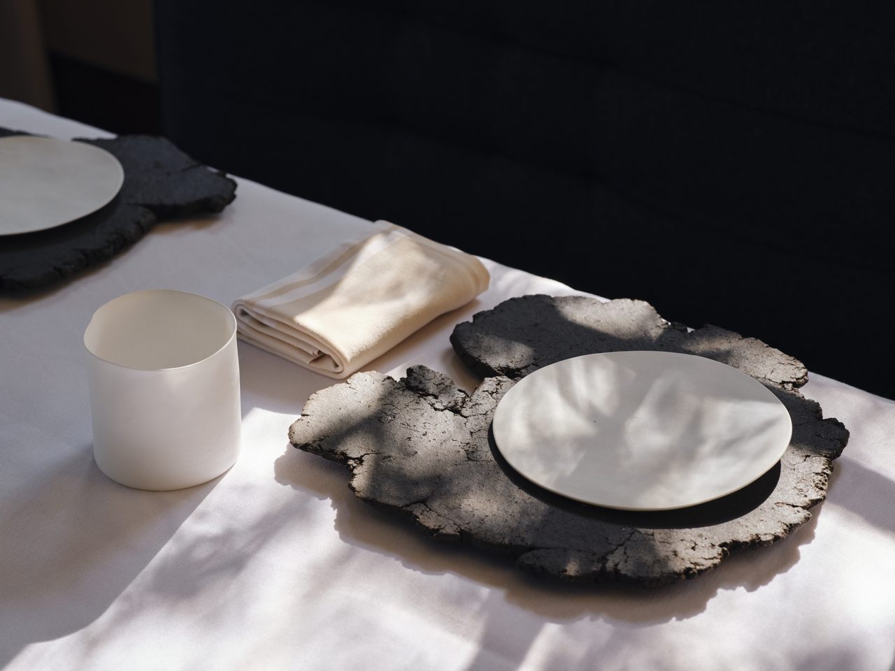 A place setting at Blue Hill at Stone Barns includes Moore's bone china water cup and plate as well as a charger made from soil. 
