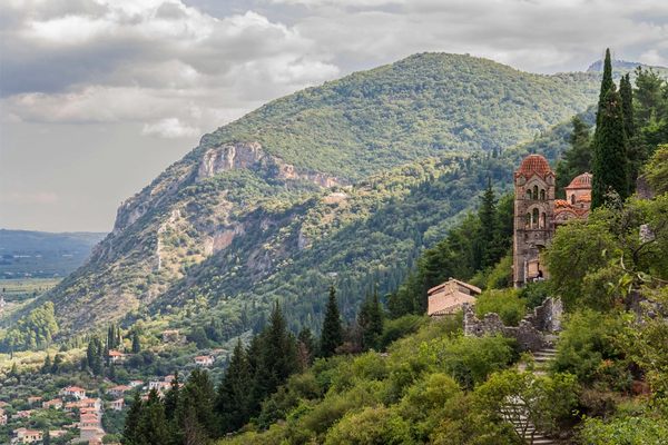View of the ruins of the byzantine city of Mystras with the church of Pantanassa, only one active, among trees.