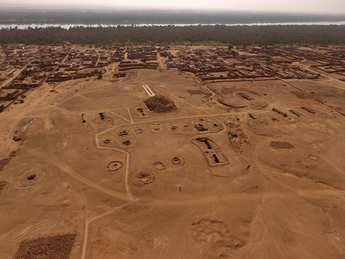 The ancient royal cemetery of El-Kurru, with the modern town of El-Kurru and the Nile in the background.