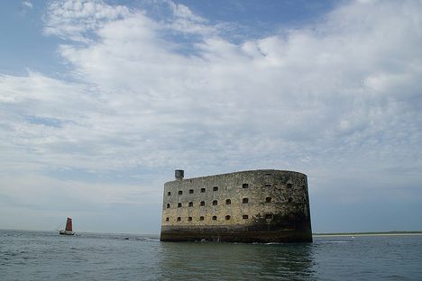 A sailboat cruises the perimeter of the fort