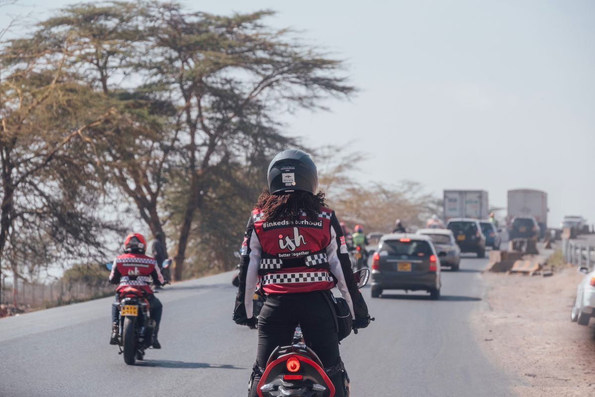 A member of the Inked Sisterhood surveys traffic ahead; the club stresses rider safety on Kenya's often dangerous roads.