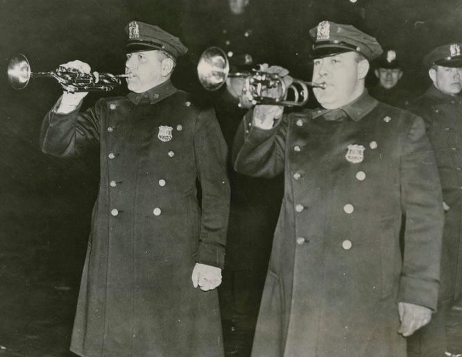 Two policemen blow trumpets to herald Mayor LaGuardia's ban on sales of artichokes.