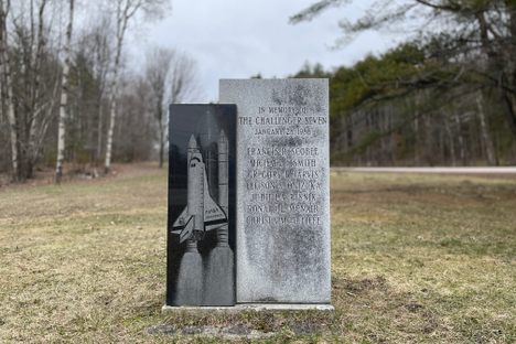 The Challenger Memorial at its prior home along Memorial Park. A block of South African granite serves as the surface for the illustration of The Challenger, while the other lists the names of the astronauts who perished in the explosion. 