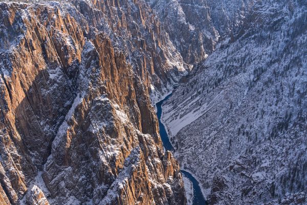 The Gunnison River is festooned by majestic steep cliffs in glorious winter light.