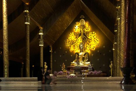 The gilded Buddha image in the main hall appears to float above the reflective flooring