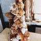 A tower of toffee dough shrouded in toffee and flowers.