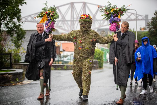 Burryman Andrew Taylor parades through South Queensferry with his attendants.