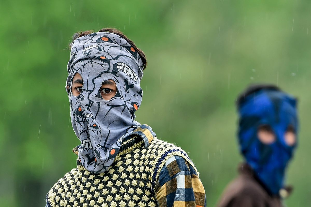 Boys in Srinagar, India, wear homemade face masks while playing cricket, April 17, 2020.