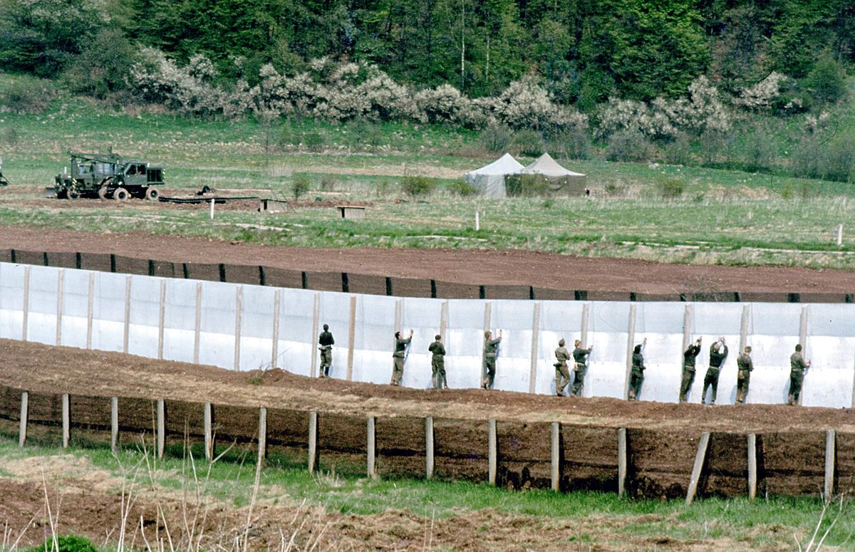 East German soldiers fortify the border fence in 1984.