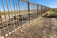 Perspective view, looking southerly, of one of the wooden slat fence surrounding one of the 1-square mile arrays.