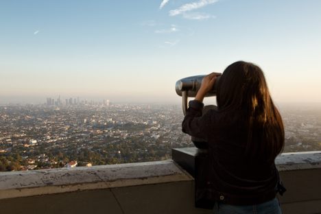 A woman looks through a tower viewer at Griffith Observatory in Los Angeles.