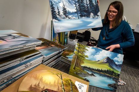 Sarah Strohl of Bob Ross Inc. sifts through stacks of scenic mountains.