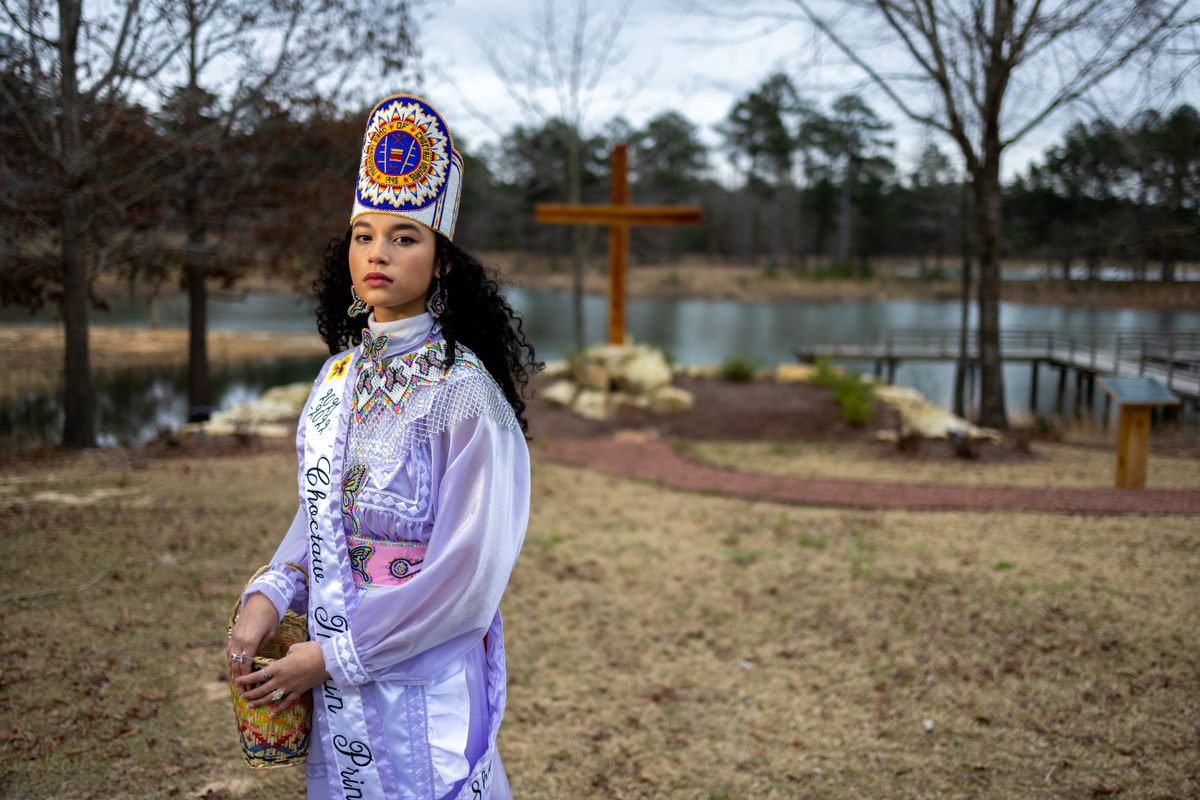 Choctaw Princess Shemah Crosby poses near a COVID-19 memorial erected by the Mississippi Band. Shemah lost her grandmother, Lena Denson, due to the pandemic, and says she regrets not learning more from her about their traditions from her. 