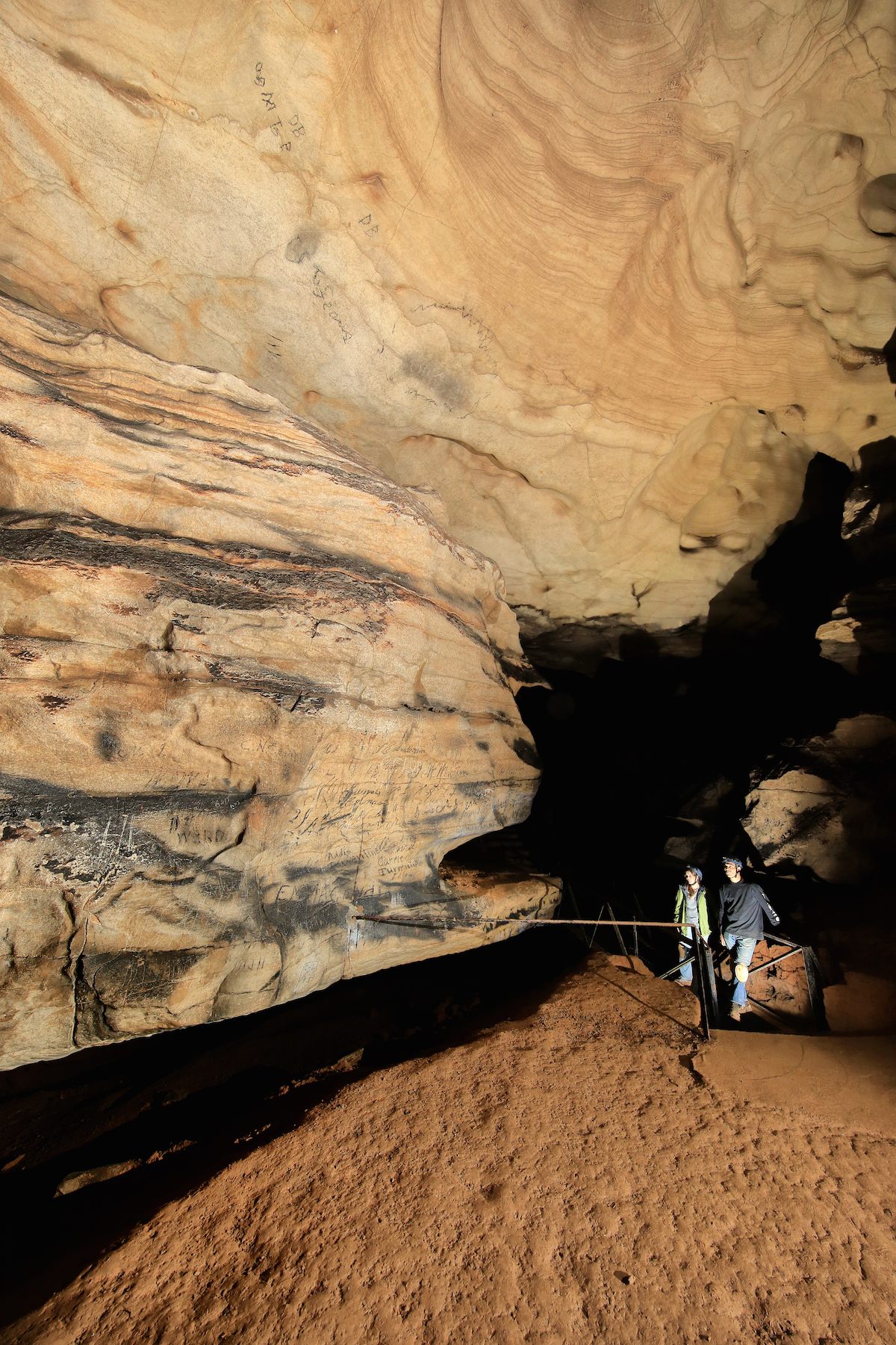 Beau Carroll and Julie Reed explore the writing on the walls of Manitou Cave.