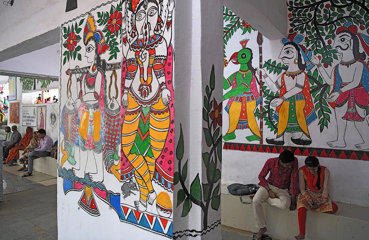 Passengers at the Madhubani railway station are surrounded by Mithila art.