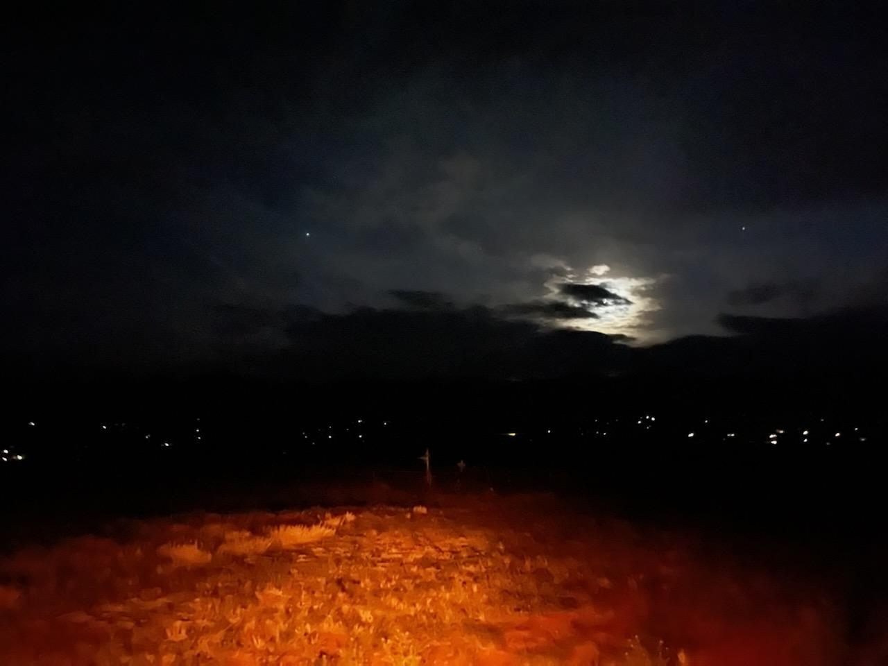 Летним вечером с кладбища видны городские огни и жуткое сияние Луны.