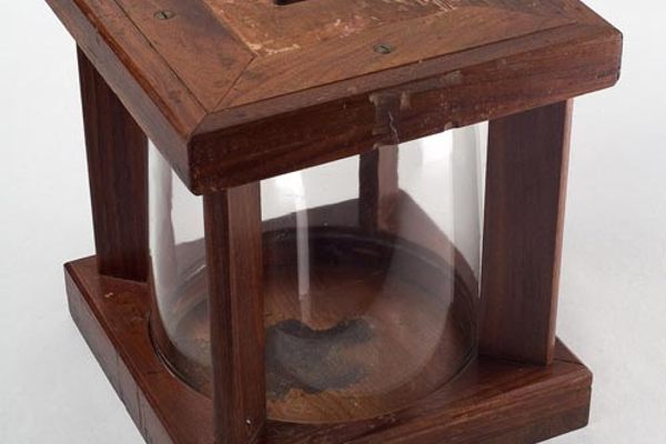 A later version of the glass ballot box with a cylindrical shape. 