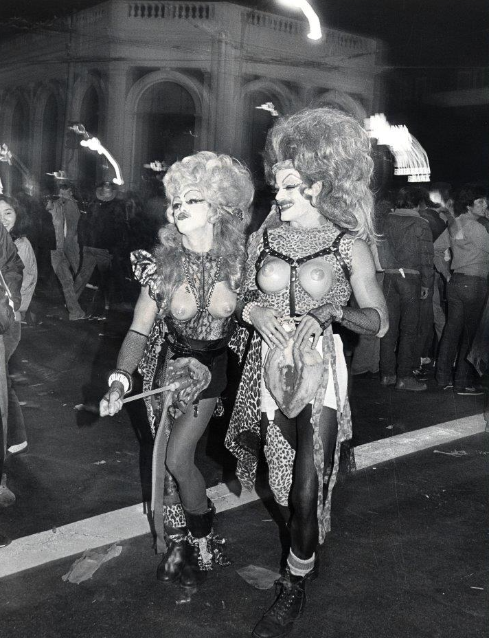 Two men dressed in drag costumes posing on Castro Street, Halloween 1982.