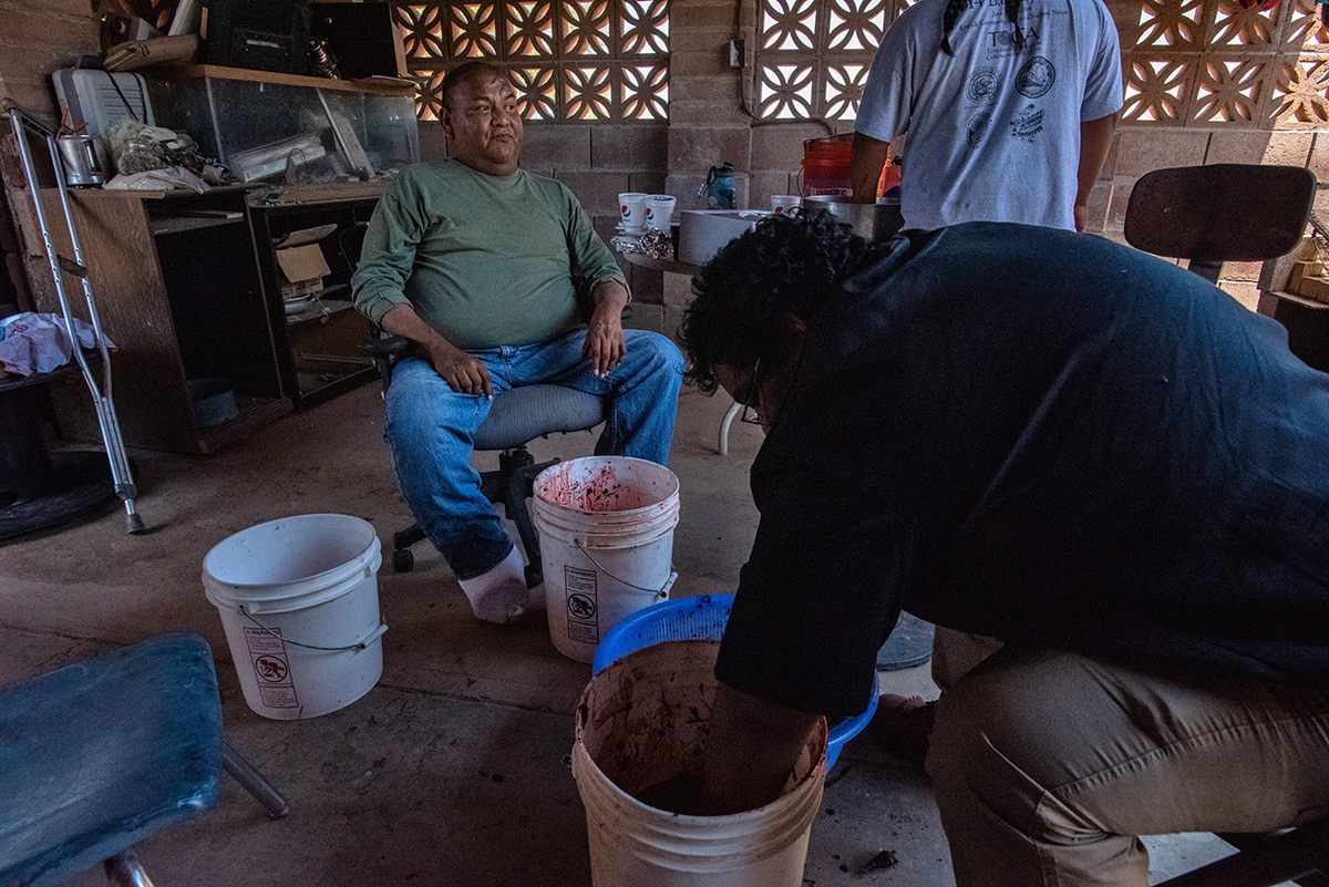 Terroll Johnson sits back for a moment while helping students learn the techniques for washing saguaro pulp. It will be cooked down into a syrup that can be stored safely for months.