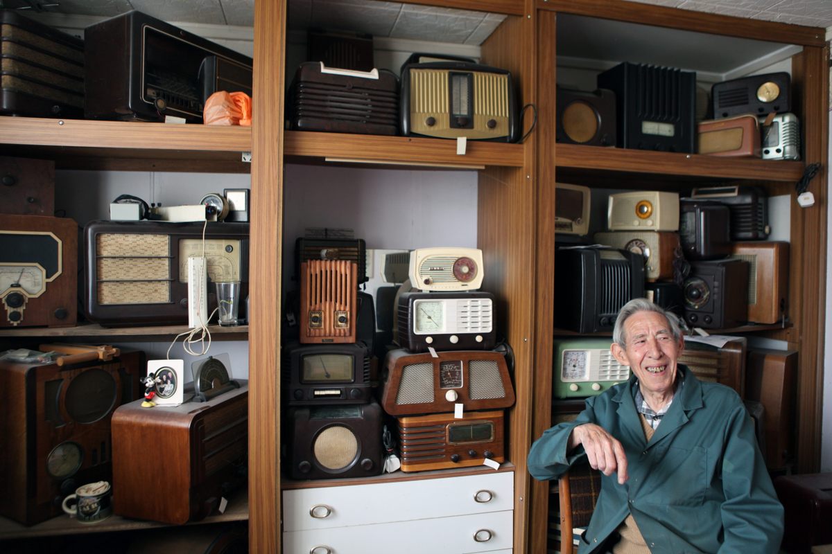 Ted Carter in one of the two bedrooms of his prefab, in front of his radios collection.
