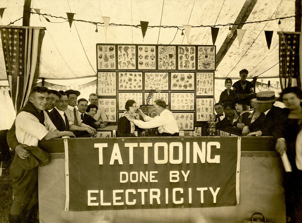 Edward "Dad" Liberty tattooing at a carnival, ca. 1923.