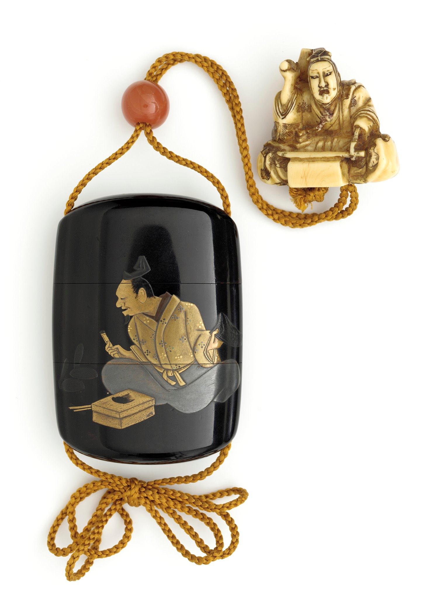 A black lacquer <em>inrō</em> carrying case anchored to an ivory netsuke.