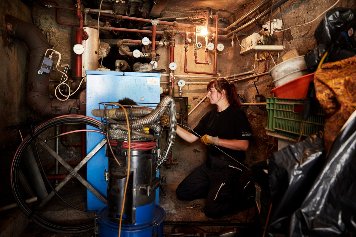 A chimney sweep can inspect five to six heating systems per day, depending on the size.  Here, Graf cleans a wood-burning furnace, which needs a visit from the chimney sweep twice a year.