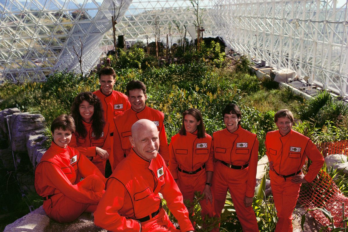 Biospherians (left to right): Jane Poynter, Linda Leigh, Mark Van Thillo, Taber MacCallum, Roy Walford (in front), Abigail Alling, Sally Silverstone, and Bernd Zabel posing inside Biosphere 2 in 1990.