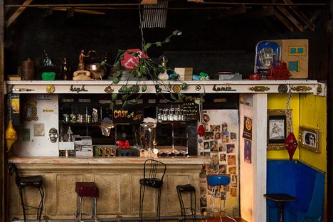 The interior of Elsie's Tavern, made of wood, paper, glass, assorted trash, an incandescent bulb, and acrylic paint.