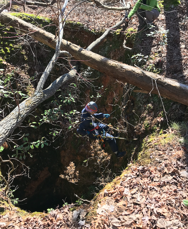 Etchison rappelling into a mine shaft.