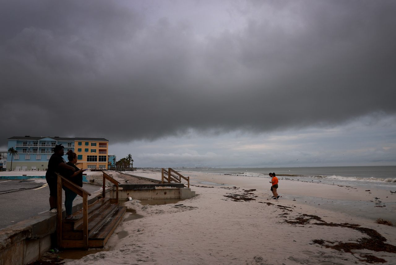 People visit the beach in in Fort Myers, Florida, as storm clouds gather ahead of Hurricane Milton's arrival.