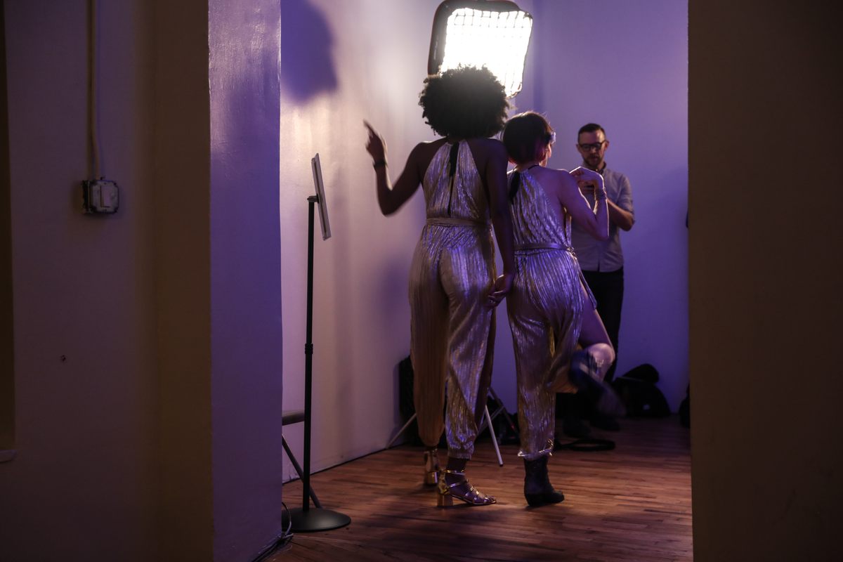 Silver-sheathed women pose for a photographer