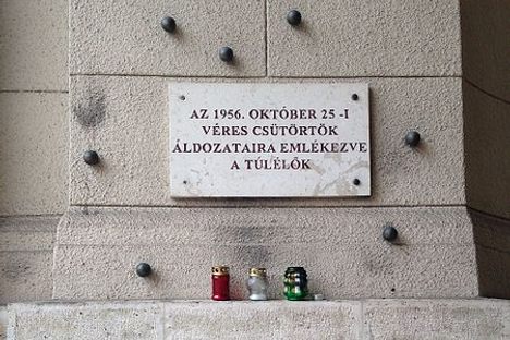 The memorial placard reads: "Dedicated to the victims of Bloody Thursday, October 25th, 1956. —The Survivors."