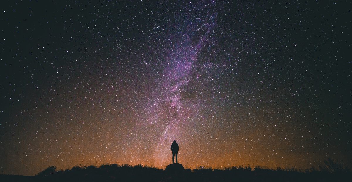 A lone figure contemplates the night sky above Utah's Tony Grove Lake.