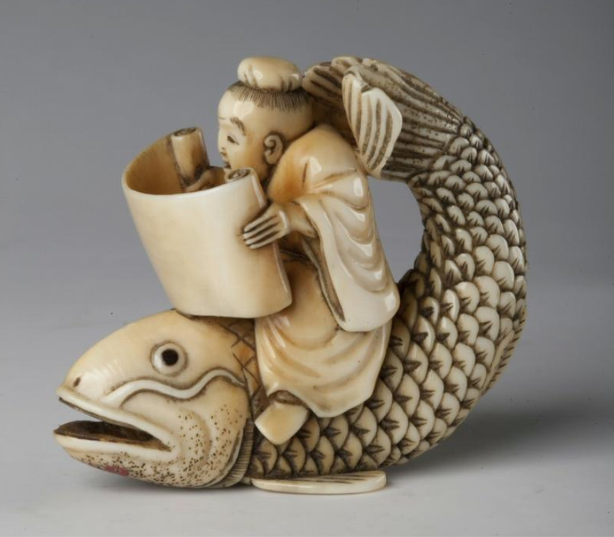 Daoist immortal Qin Gao riding a carp and reading a scroll, as one does.