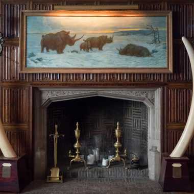 The fireplace adorned by elephant tusks.