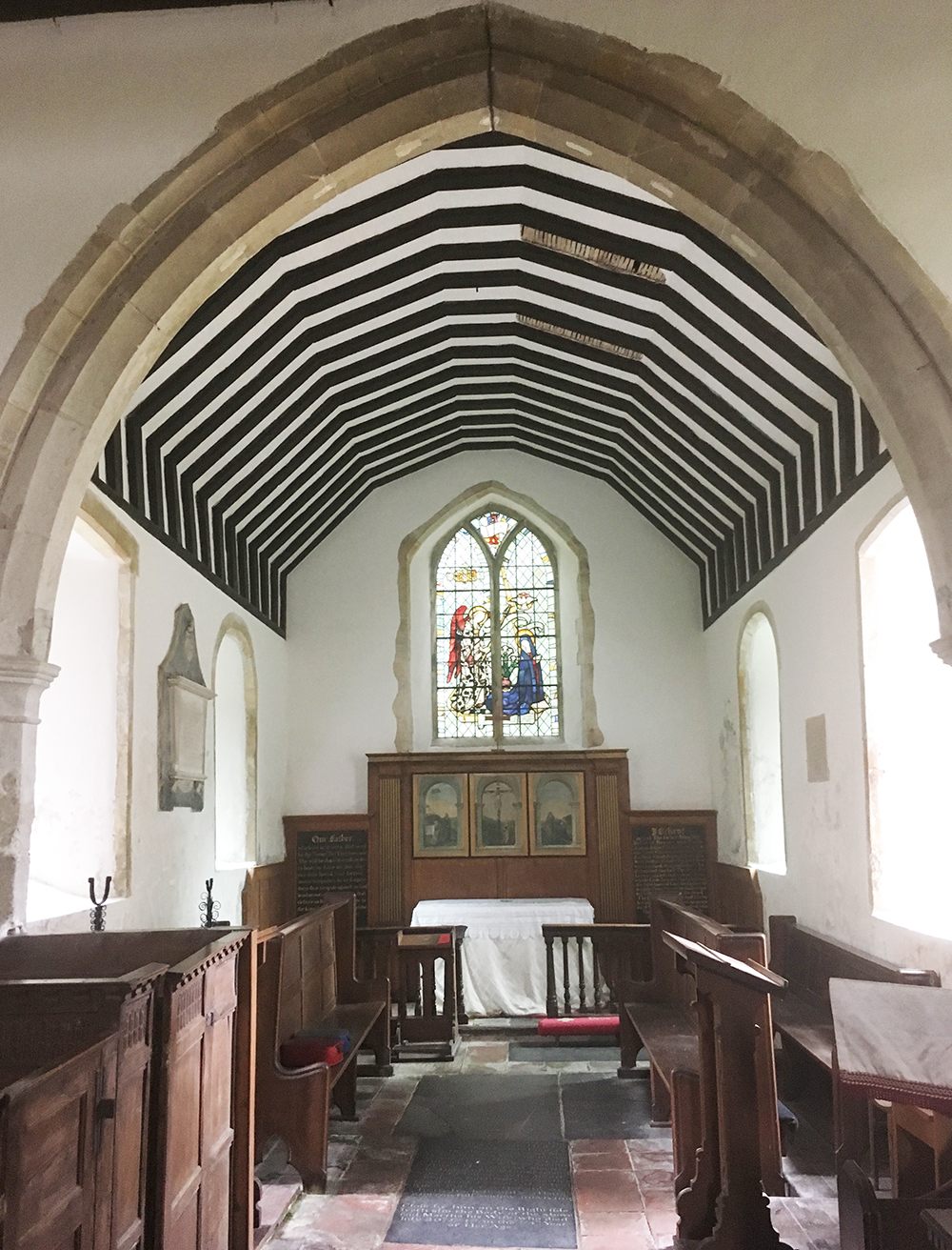 Chancel arch, with stain glass of royal arms of James II.