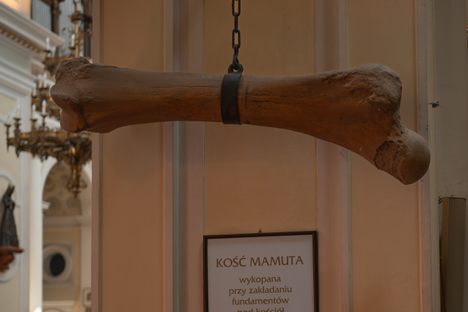 A large bone hangs from a chain in a church.