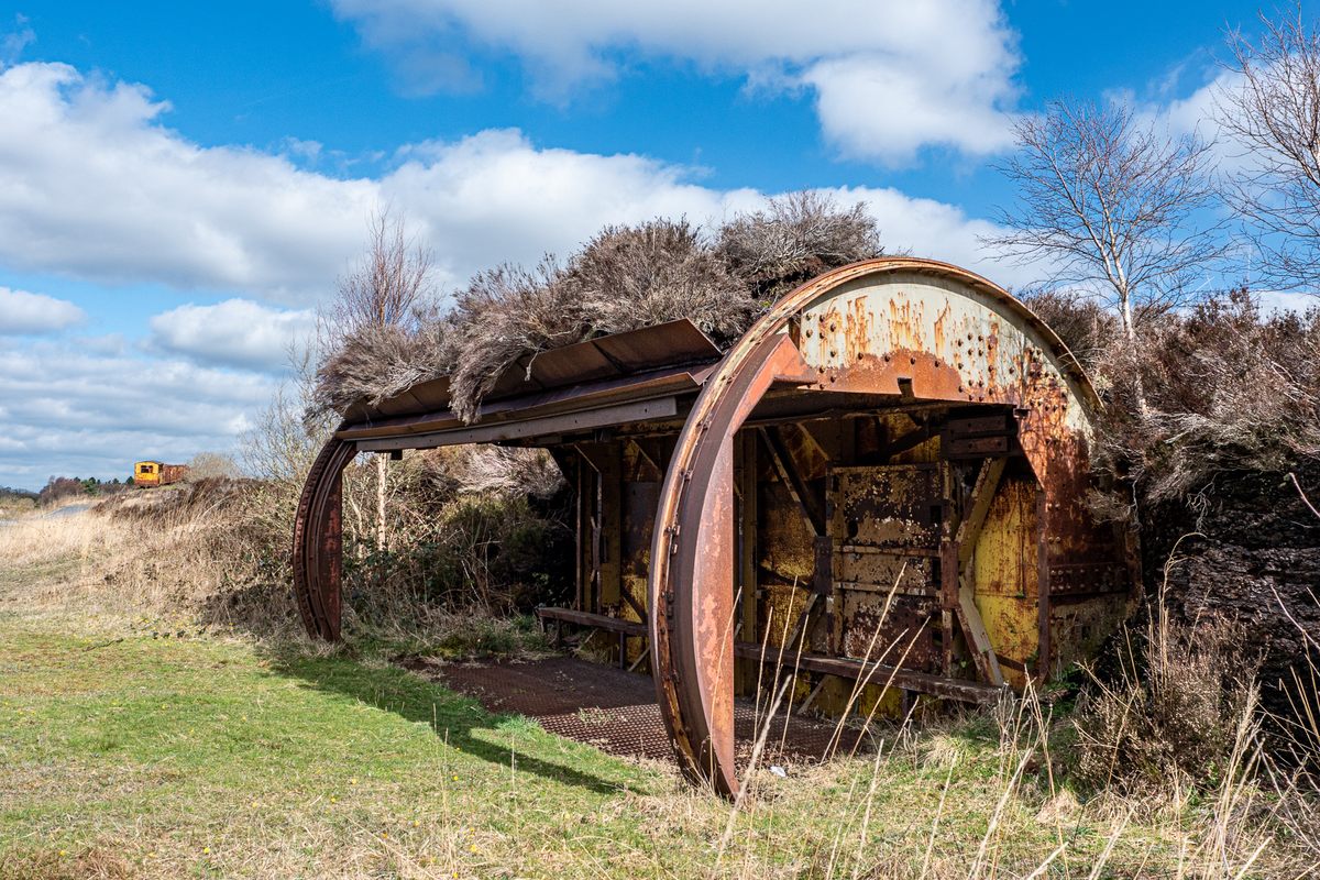 An old steel “tippler,” a huge cylinder that dumped load after load of peat-filled train cars, is now an outdoor shelter with a green roof.