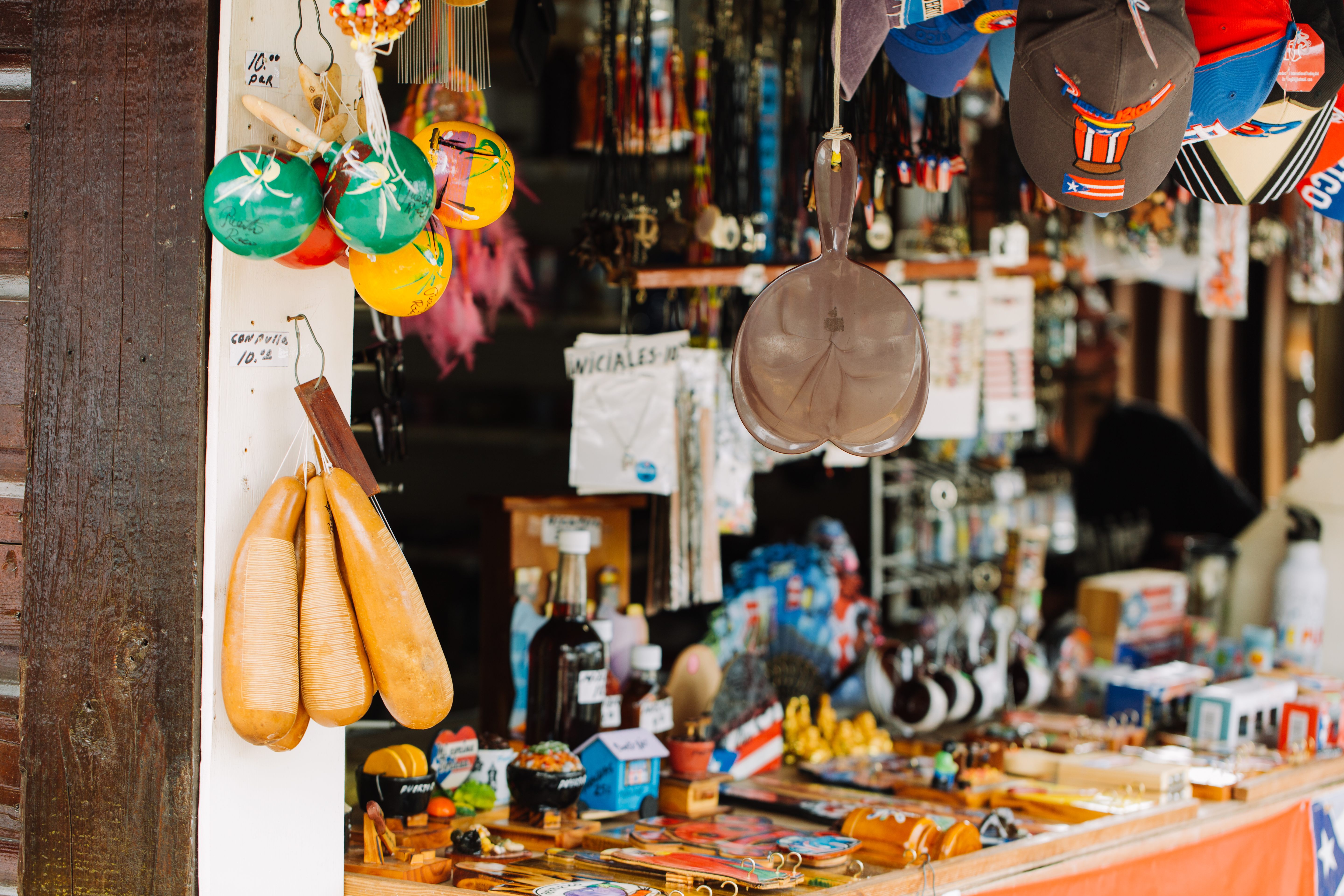 Vendors sell hand-woven hammocks, handmade jewelry, ceramics, souvenirs, and wood-carved pilones along the road.
