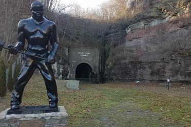 An eight-foot bronze statue honoring the legacy of John Henry stands at the entrance of the Great Bend Tunnel in Talcott, West Virginia. 